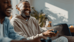 Two men happily playing video games on the couch