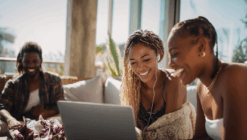 Two women happily gazing at a laptop